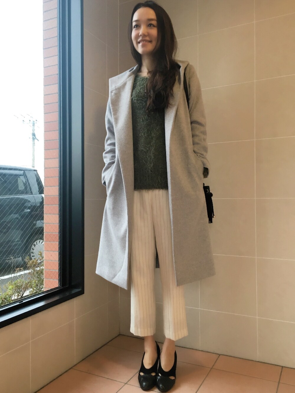 ホワイト系のその他パンツ、グリーン系のニット/セーター、グレー系のその他アウターを着用したレディースの冬コーディネートの1枚目の写真