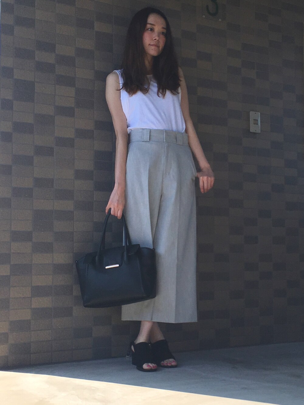 グレー系のその他パンツ、ブラック系のトートバッグ、ブラック系のサンダルを着用したレディースの夏コーディネートの1枚目の写真