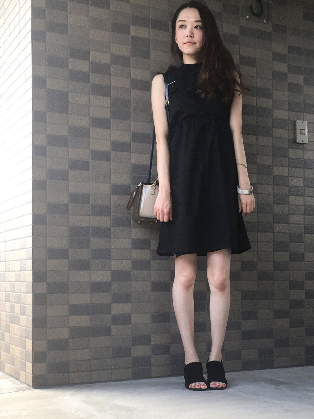 ブラック系のワンピース、その他のショルダーバッグ、ブラック系のサンダルを着用したレディースの夏コーディネートの1枚目の写真