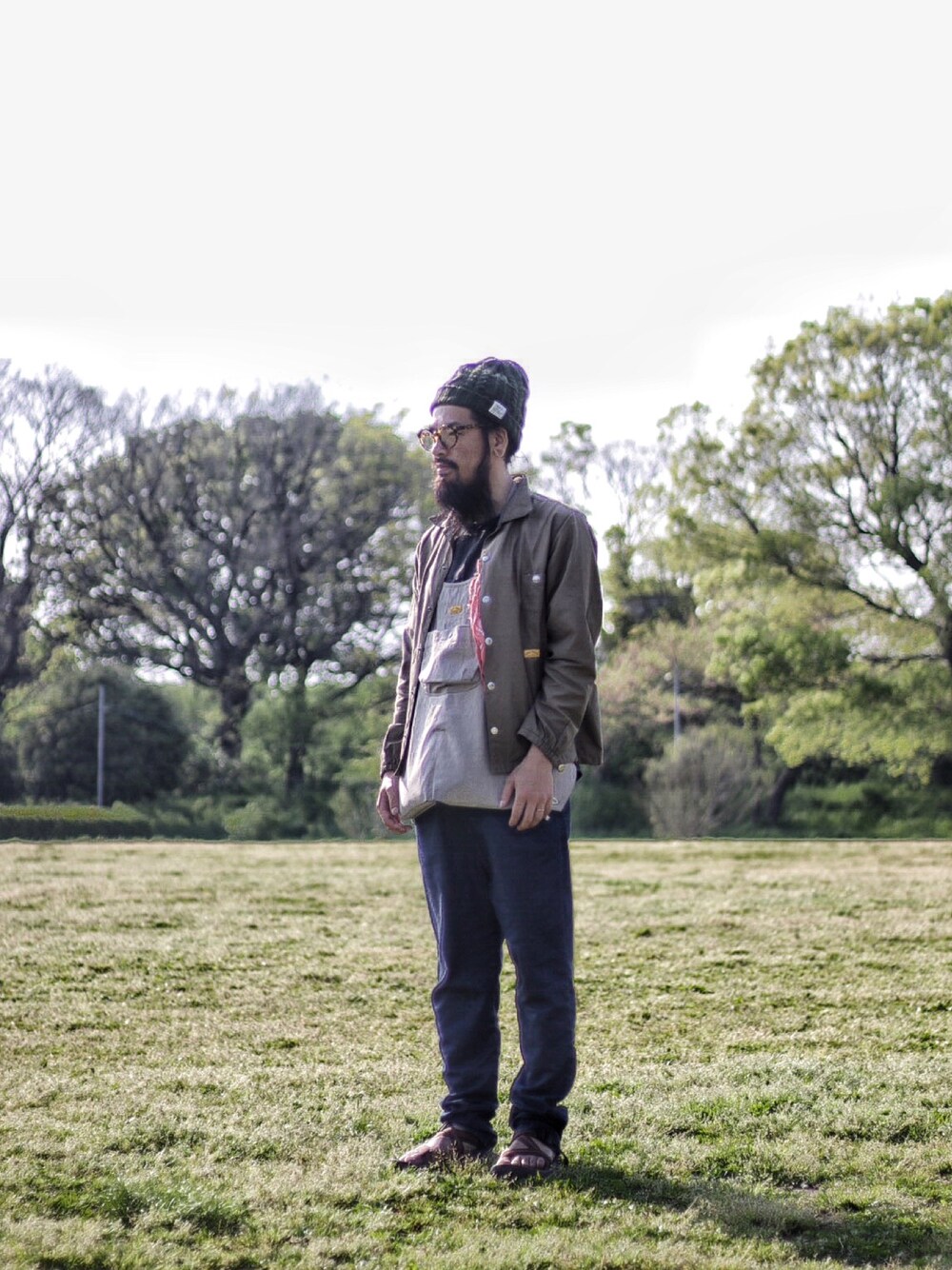 グレー系のその他トップス、ブルー系のデニムパンツ、グリーン系のナイロンジャケットを着用したメンズの春コーディネートの1枚目の写真