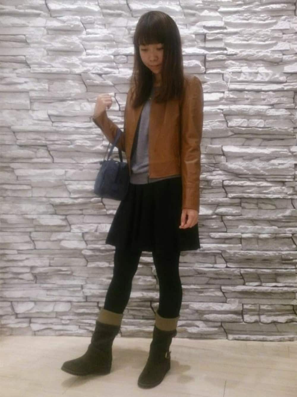 グリーン系のブーツ、ブルー系のショルダーバッグを着用したレディースの秋コーディネートの1枚目の写真