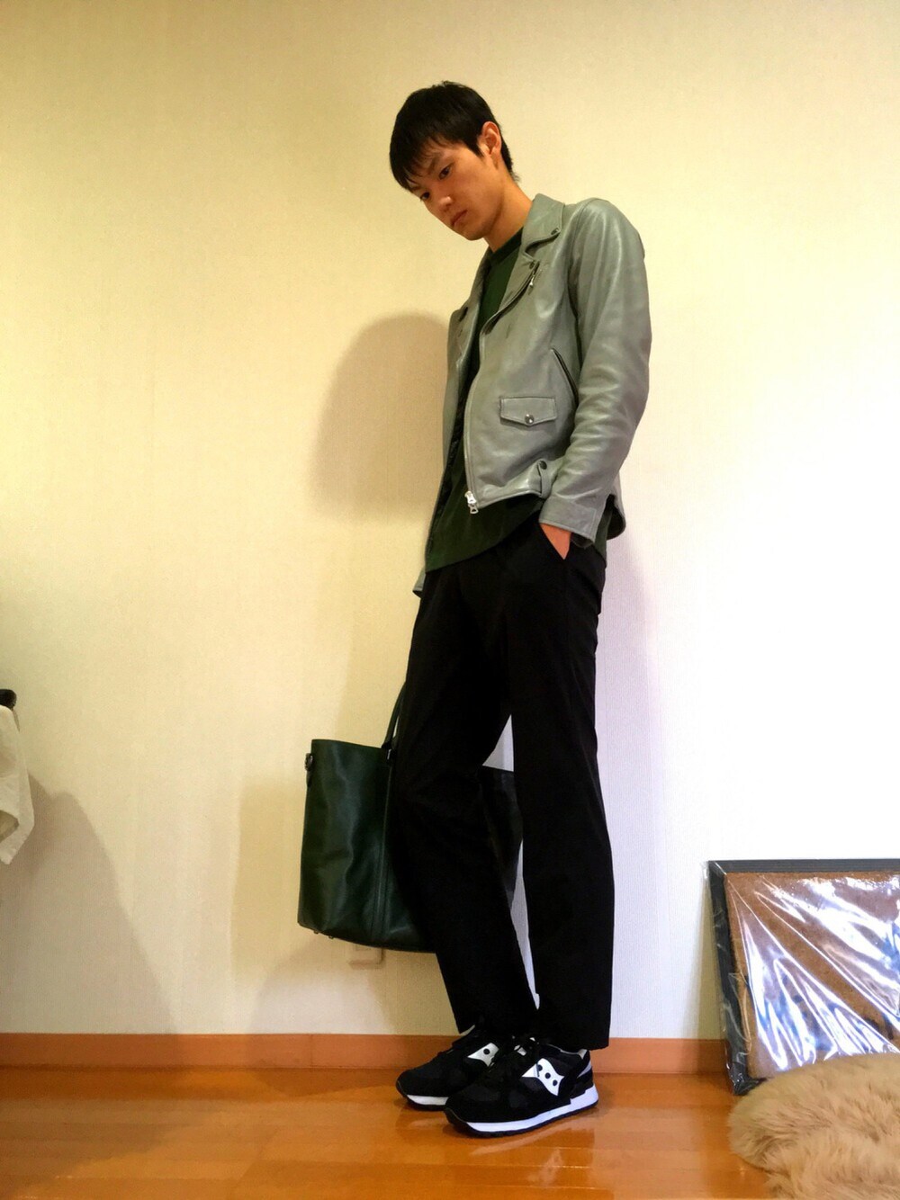 グレー系のライダースジャケット、ブラック系のその他パンツ、グリーン系のトートバッグを着用したメンズの秋コーディネートの1枚目の写真