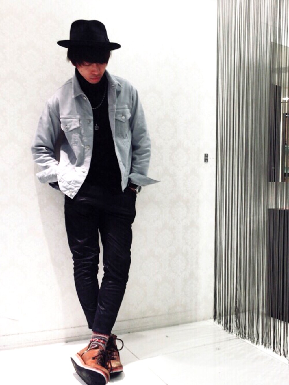 ブラウン系のブーツ、ブルー系のデニムジャケット、ブラック系のニット/セーターを着用したメンズの春コーディネートの1枚目の写真