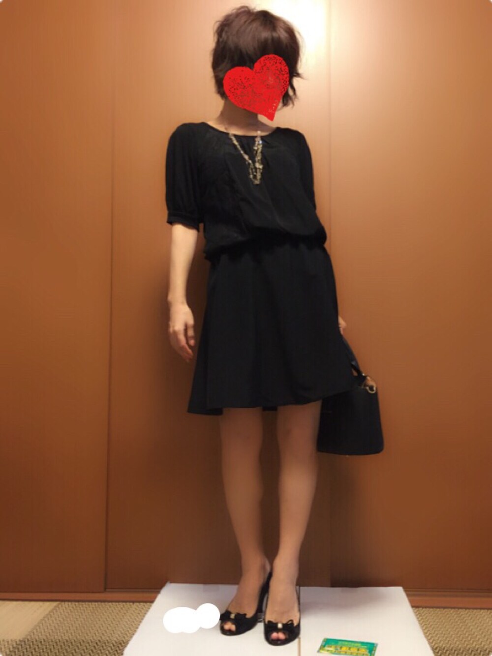 ブラック系のパンプス、ブラック系のハンドバッグ、ブラック系のワンピースを着用したレディースの秋コーディネートの1枚目の写真