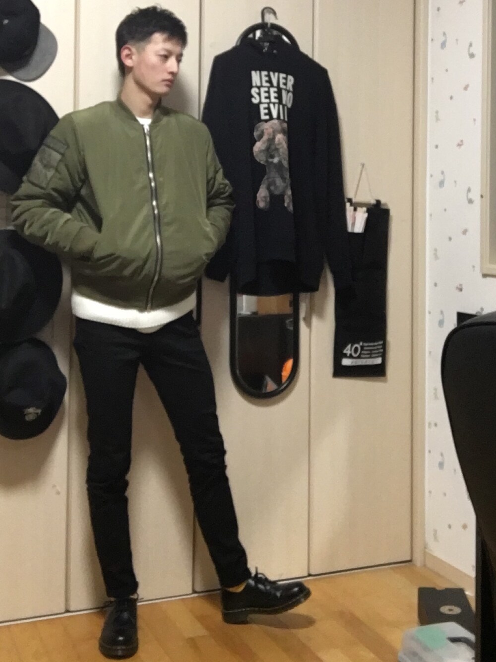 ブラック系のブーツ、ブラック系のデニムパンツ、ホワイト系のニット/セーターを着用したメンズの冬コーディネートの1枚目の写真