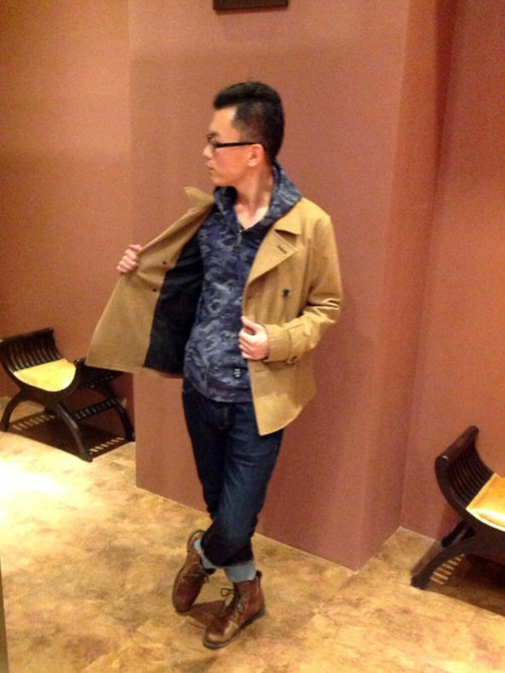 ブラウン系のピーコート、ブルー系のパーカー、ブルー系のデニムパンツを着用したメンズの冬コーディネートの1枚目の写真