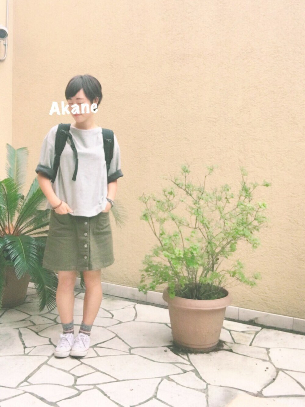 グレー系のスウェット、ブラック系のバックパック/リュック、グリーン系のスカートを着用したレディースの秋コーディネートの1枚目の写真