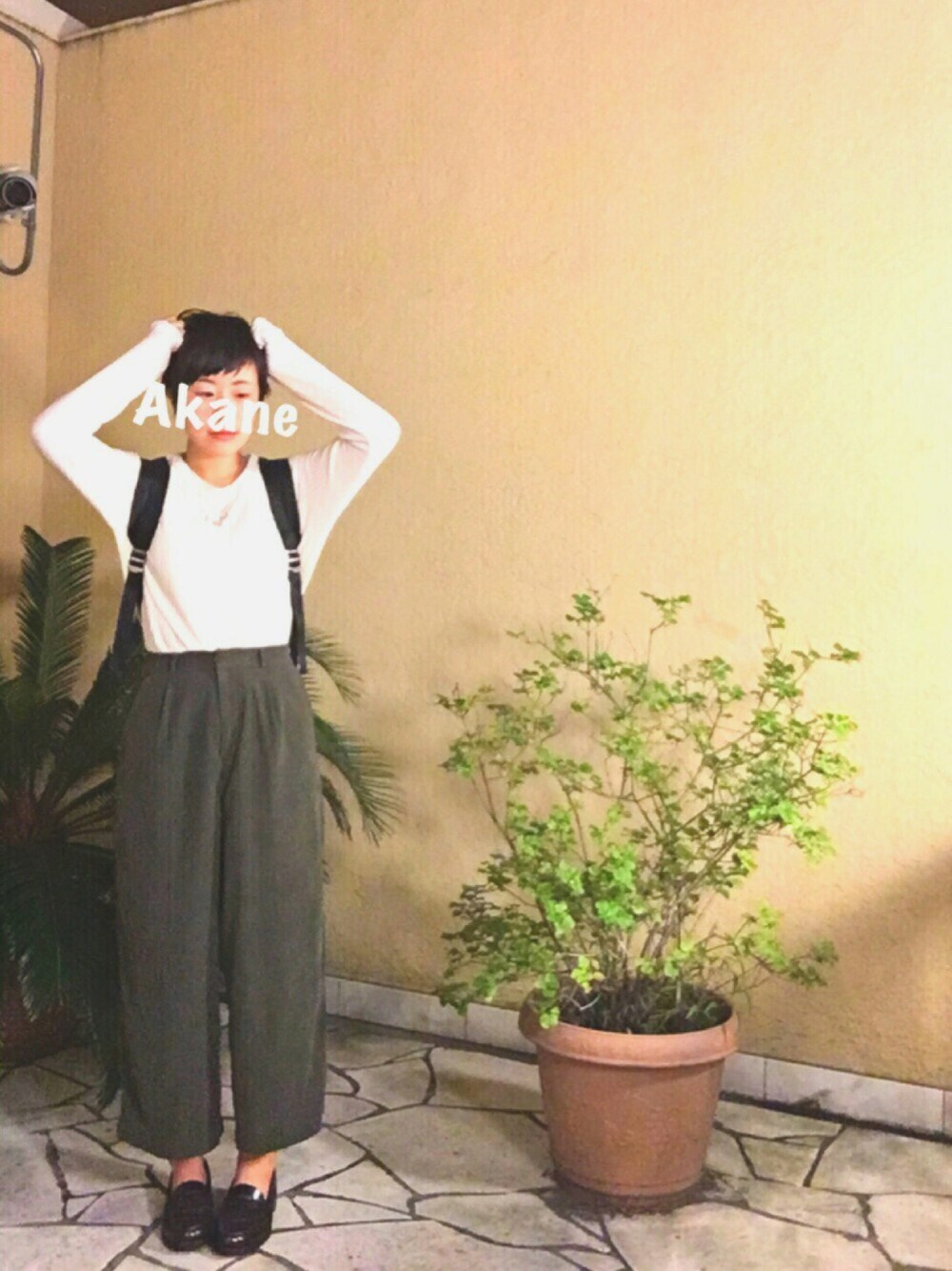 ホワイト系のトップス、ブラック系のバックパック/リュック、グリーン系のその他パンツを着用したレディースの秋コーディネートの1枚目の写真