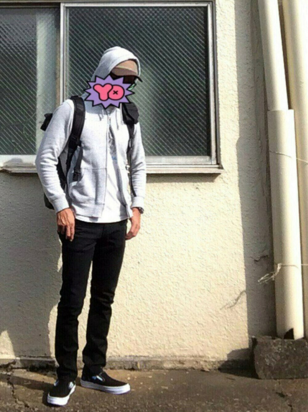 ブラック系のデニムパンツ、ブラック系のスニーカー、グレー系のパーカーを着用したメンズの秋コーディネートの1枚目の写真