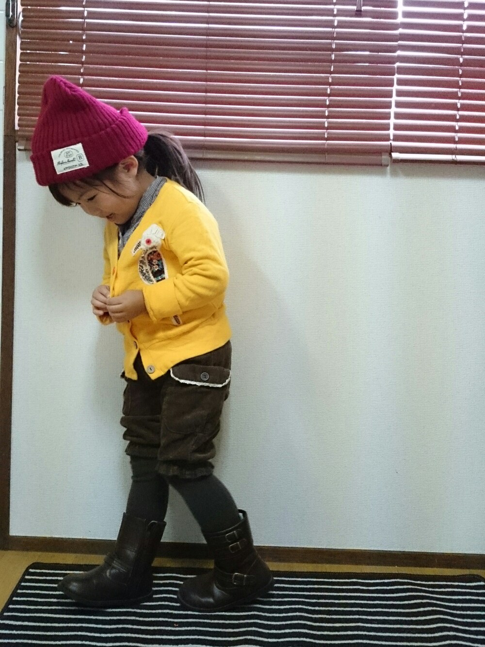 ブラウン系のシャツ/ブラウス、ブラウン系のブーツ、イエロー系のカーディガン/ボレロを着用したキッズの秋コーディネートの1枚目の写真