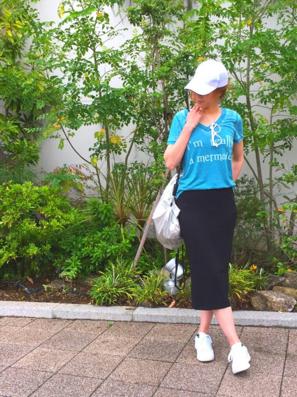 グリーン系のTシャツ/カットソー、シルバー系のバックパック/リュック、ブラック系のスカートを着用したレディースの夏コーディネートの1枚目の写真