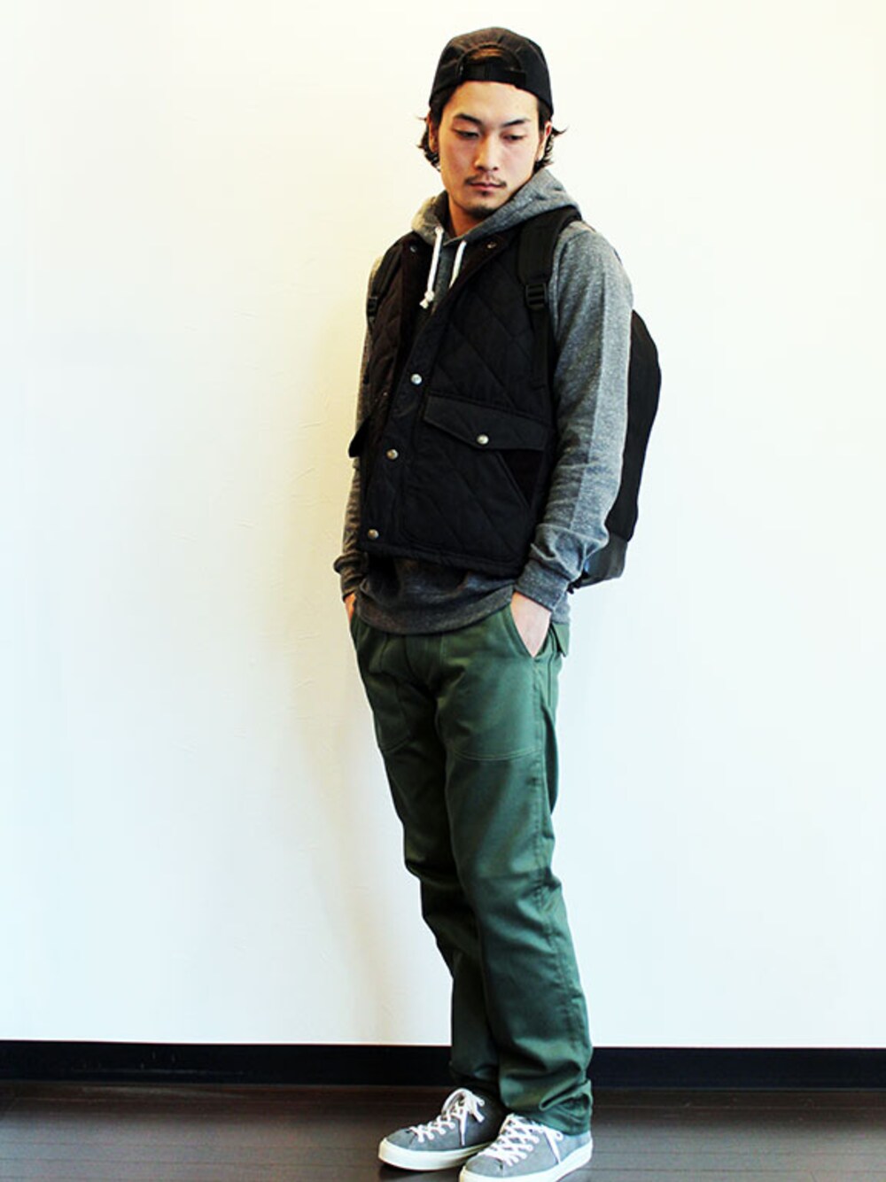 ブラック系のベスト、グレー系のパーカー、グリーン系のその他パンツを着用したメンズの春コーディネートの1枚目の写真