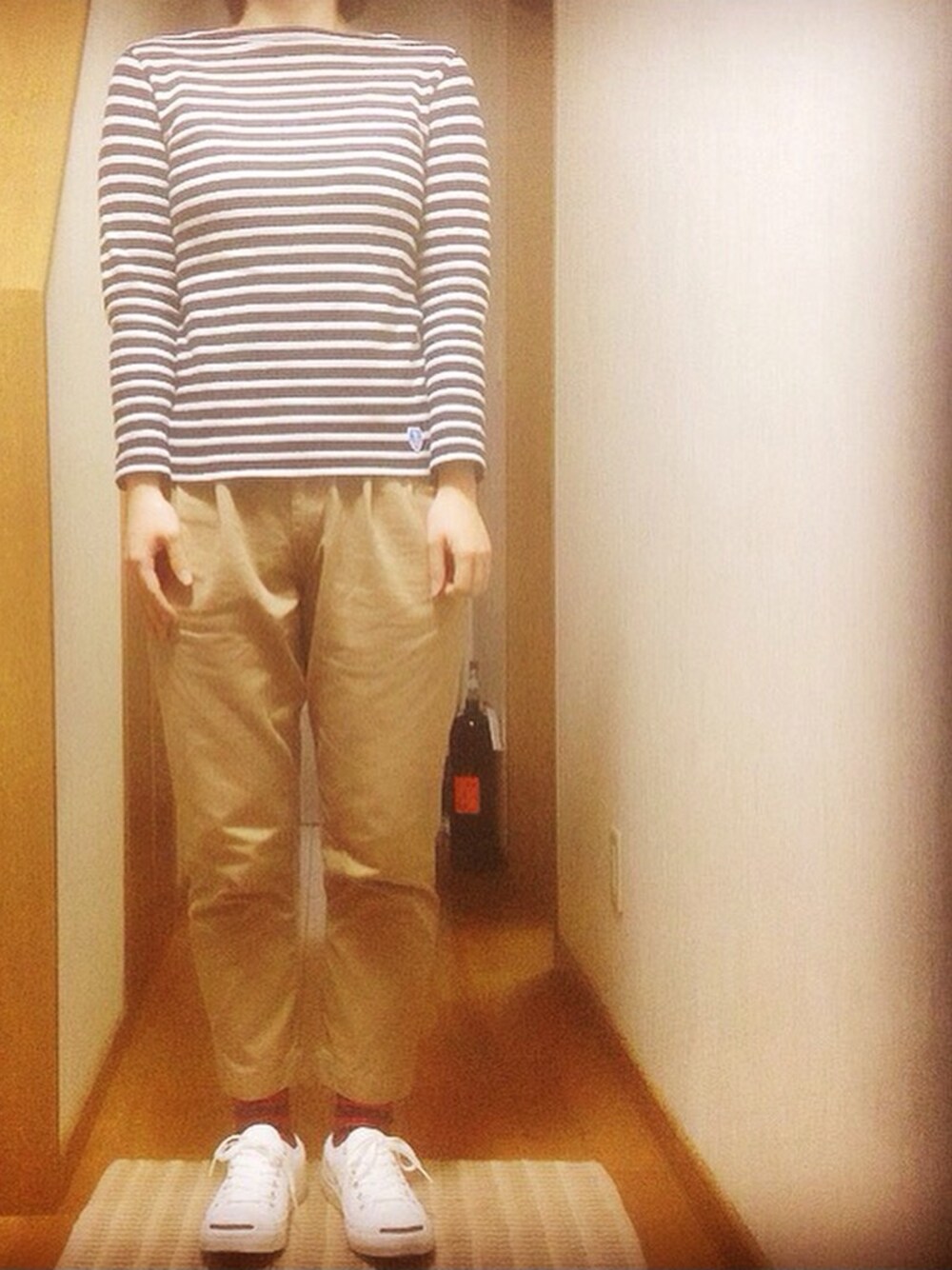 ブルー系のTシャツ/カットソー、ベージュ系のチノパンツ、ホワイト系のスニーカーを着用したレディースの冬コーディネートの1枚目の写真