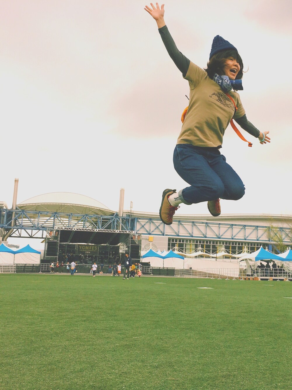 グリーン系のボディバッグ/ウエストポーチ、ブルー系のデニムパンツ、ベージュ系のスニーカーを着用したレディースの春コーディネートの1枚目の写真