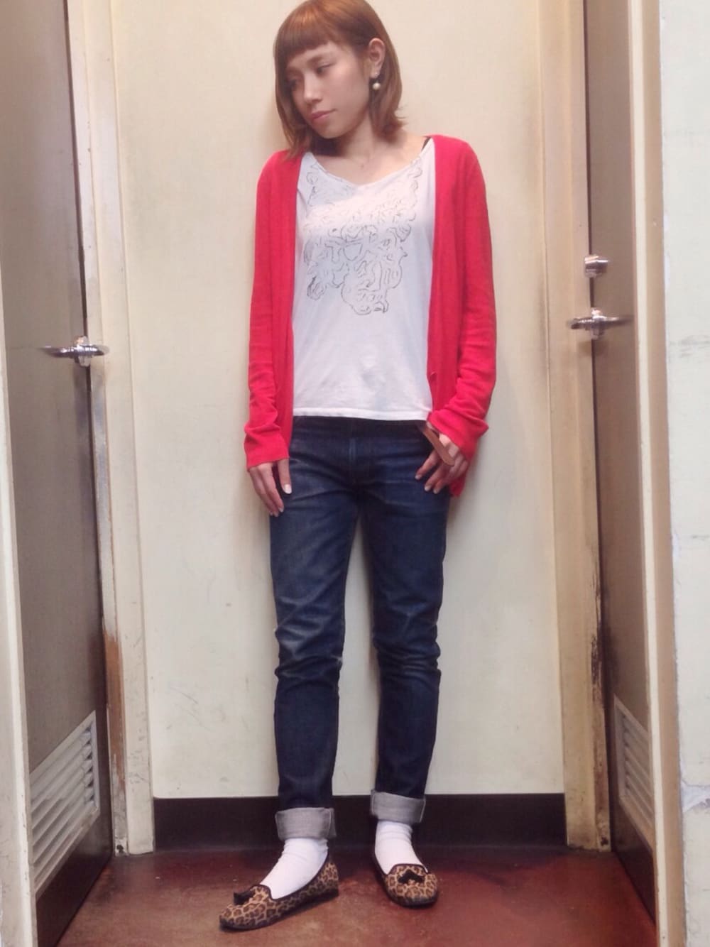 ホワイト系のTシャツ/カットソー、レッド系のカーディガン/ボレロ、ブルー系のデニムパンツを着用したレディースの冬コーディネートの1枚目の写真