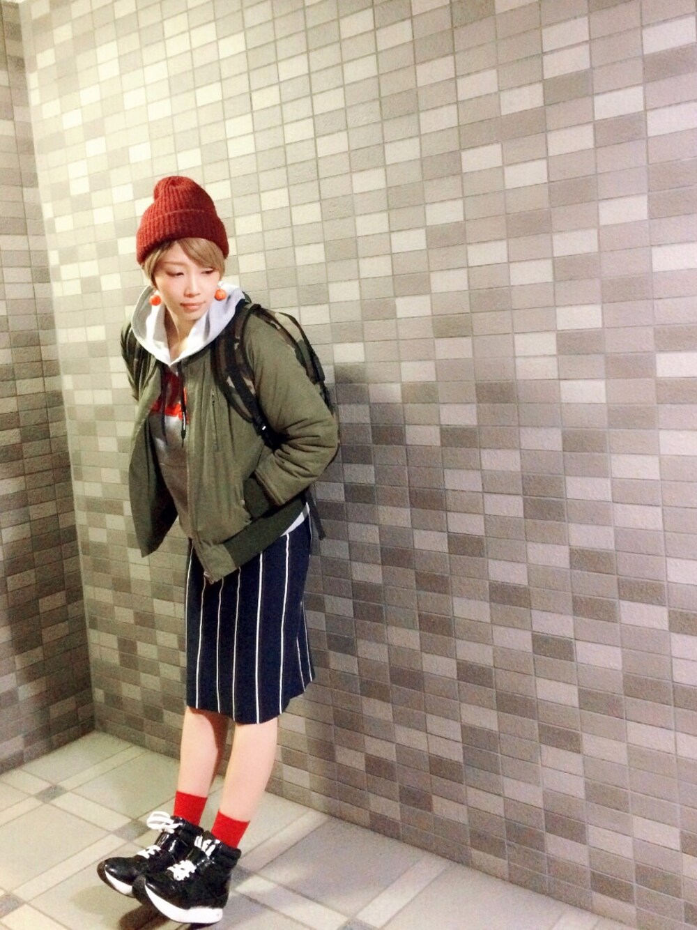 ブルー系のスカート、グリーン系のミリタリージャケットを着用したレディースの冬コーディネートの1枚目の写真