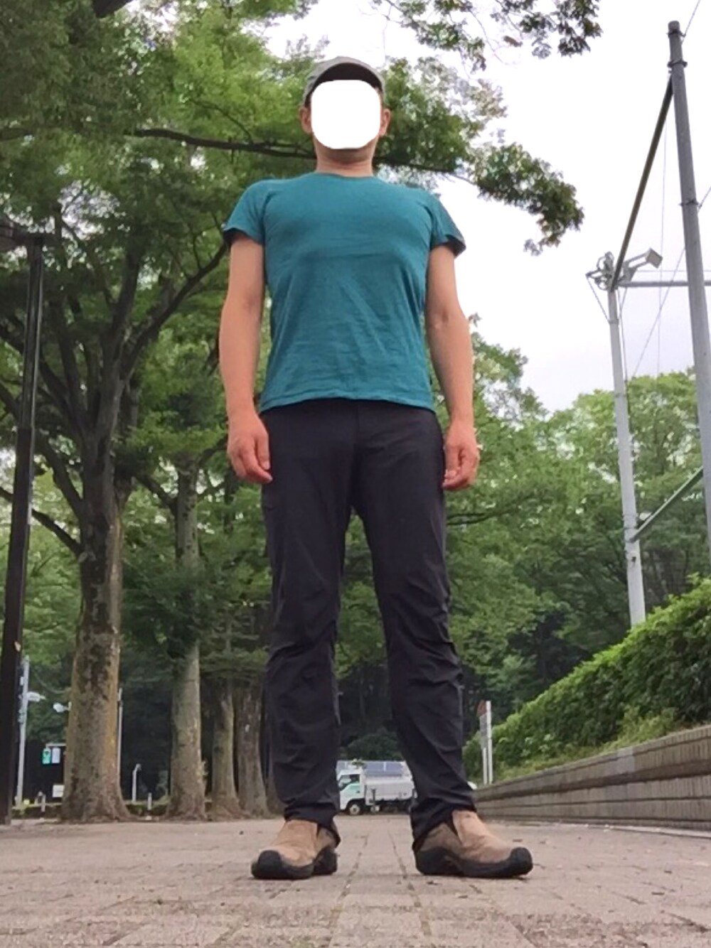 グリーン系のTシャツ/カットソー、ブラック系のチノパンツ、ベージュ系のスニーカーを着用したメンズの夏コーディネートの1枚目の写真