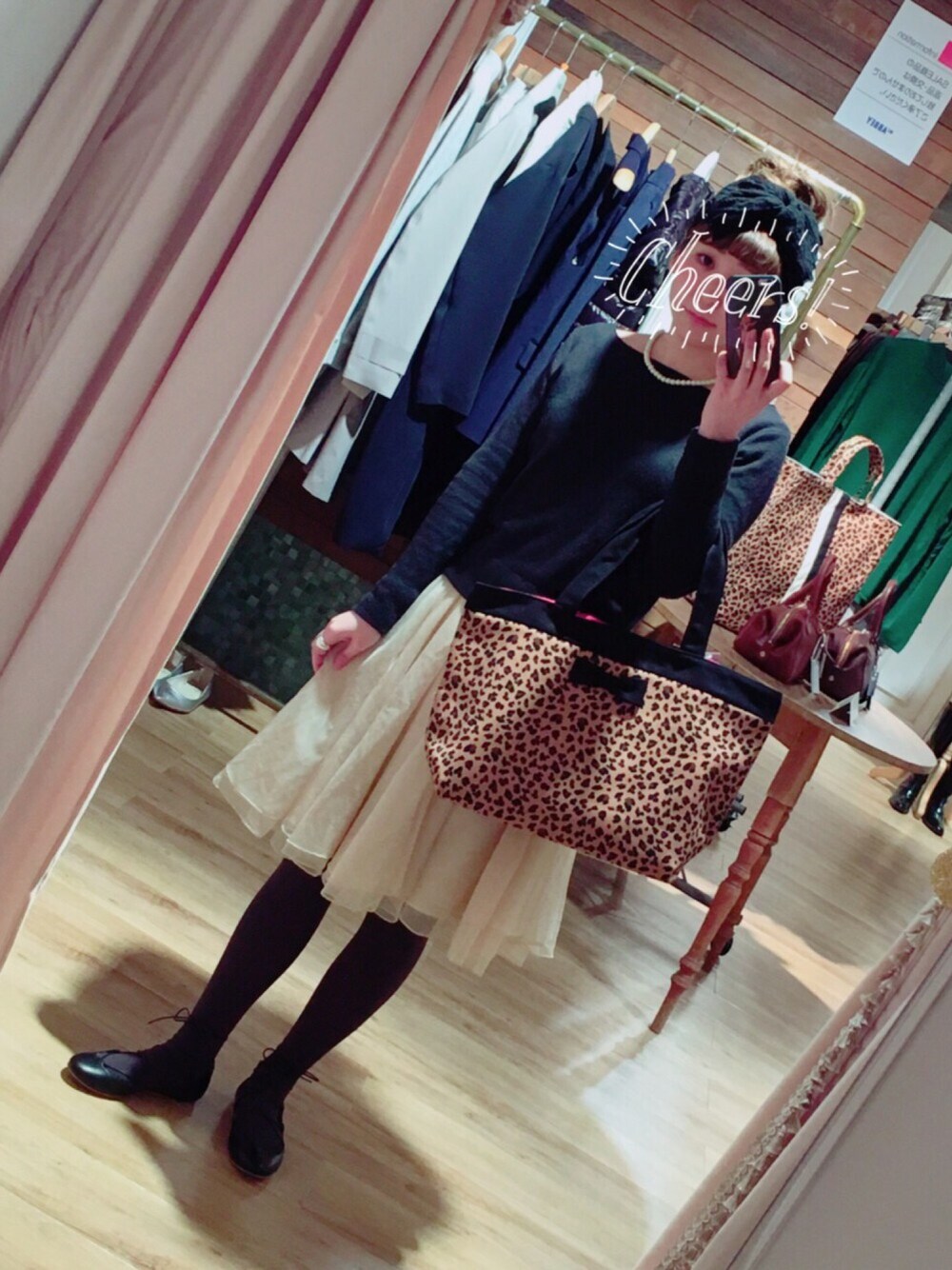 ブラウン系のトートバッグ、ホワイト系のスカート、ブラック系のニット/セーターを着用したレディースの冬コーディネートの1枚目の写真