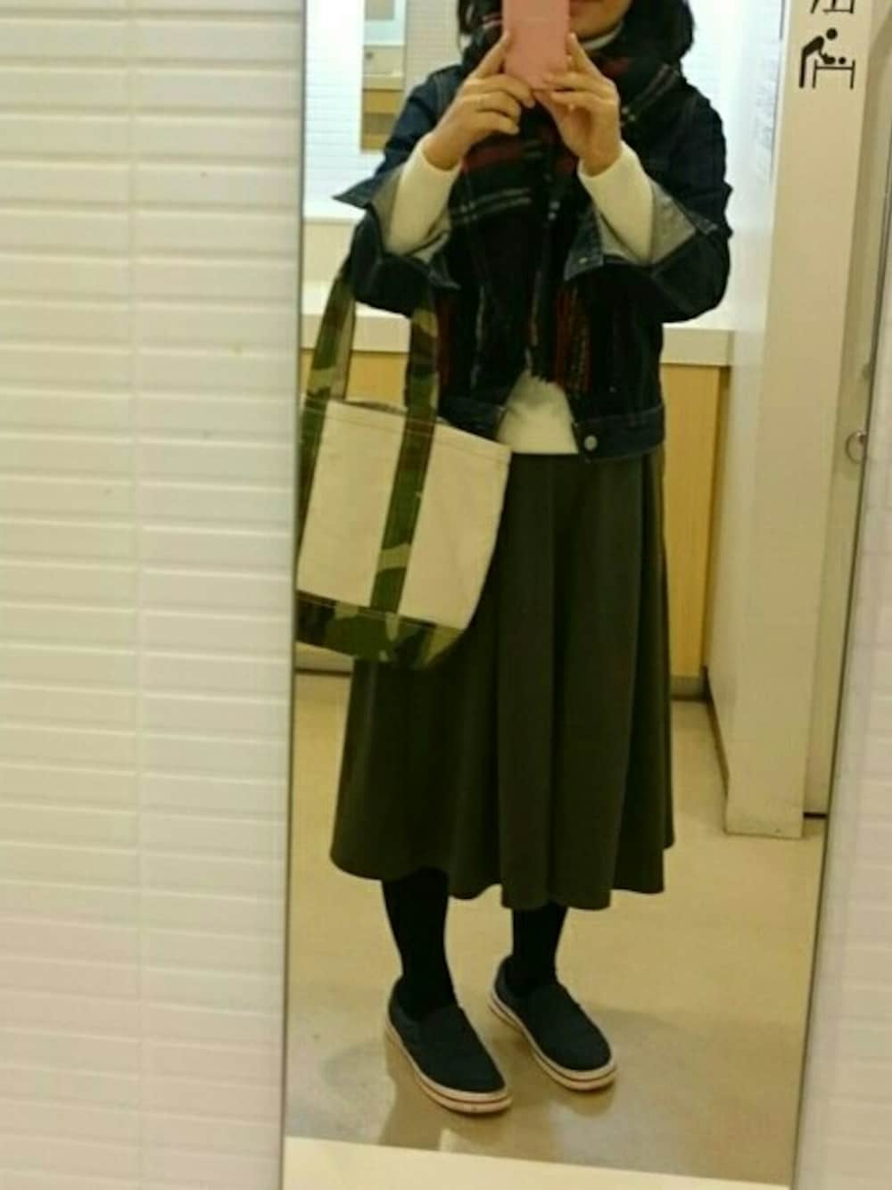 ブルー系のデニムジャケット、ブルー系のシューズ、グリーン系のパンツを着用したレディースの冬コーディネートの1枚目の写真