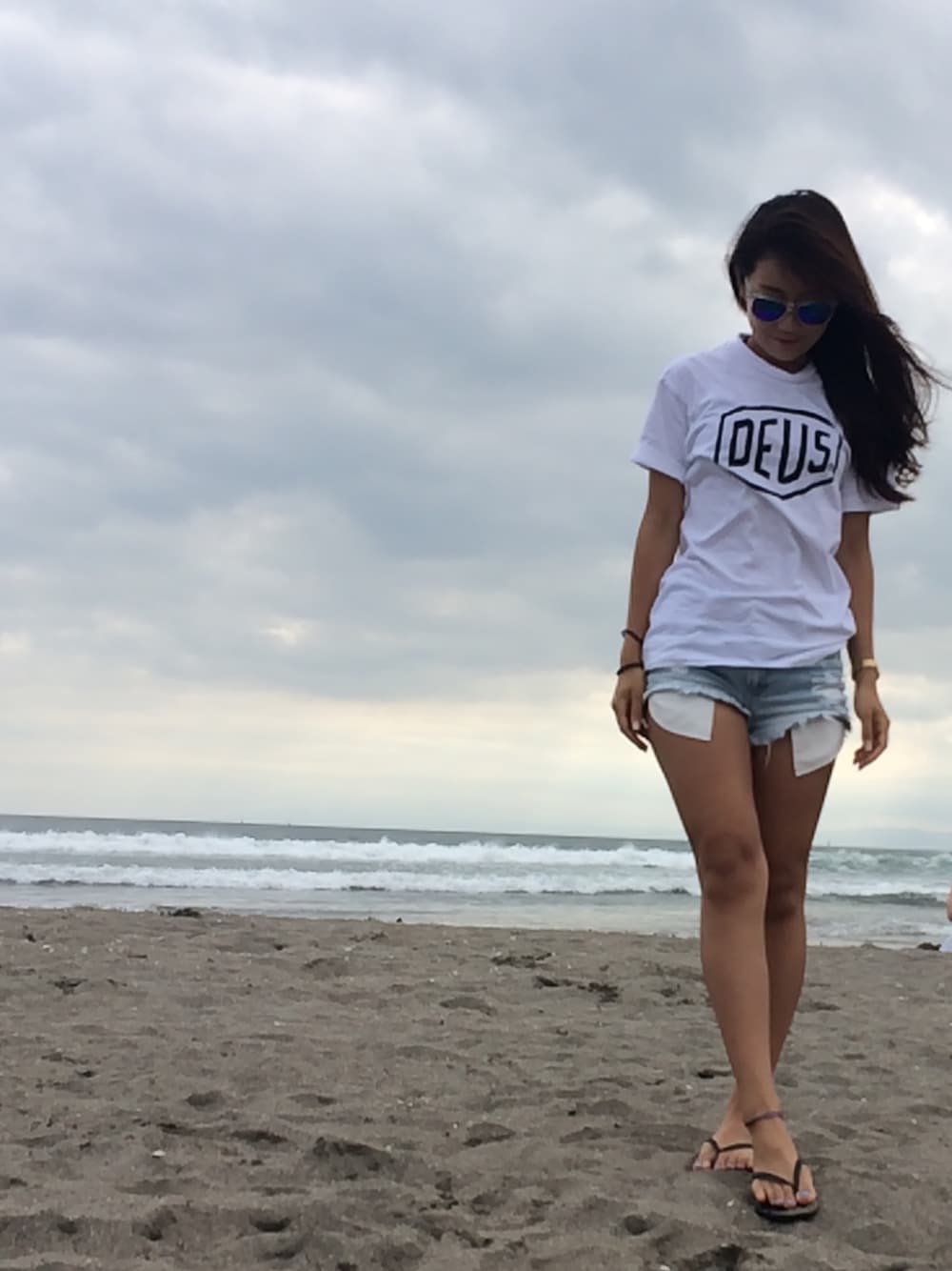 ホワイト系のTシャツ/カットソー、ブルー系のデニムパンツ、ブラック系のビーチサンダルを着用したレディースの夏コーディネートの1枚目の写真