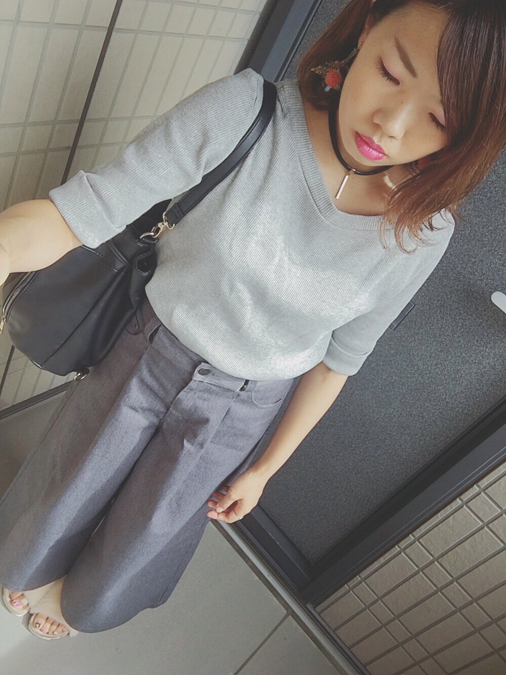 グレー系のTシャツ/カットソー、グレー系のチノパンツ、ホワイト系のサンダルを着用したレディースの秋コーディネートの1枚目の写真