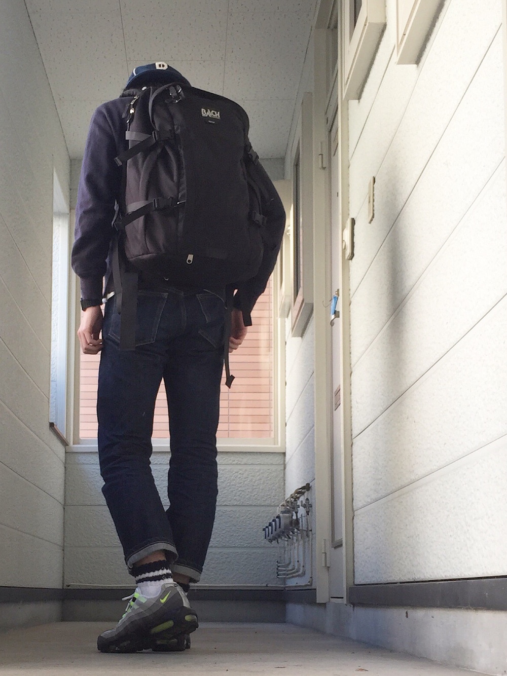 ブルー系のスウェット、ブラック系のバックパック/リュック、ブルー系のデニムパンツを着用したメンズの秋コーディネートの1枚目の写真