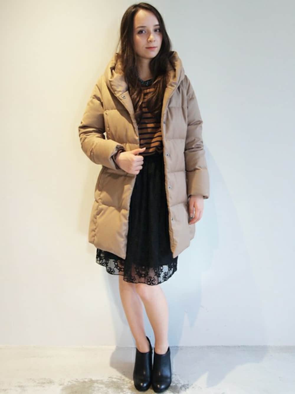 ブラック系のブーツ、ブラック系のスカート、ベージュ系のダウンジャケット/コートを着用したレディースの秋コーディネートの1枚目の写真