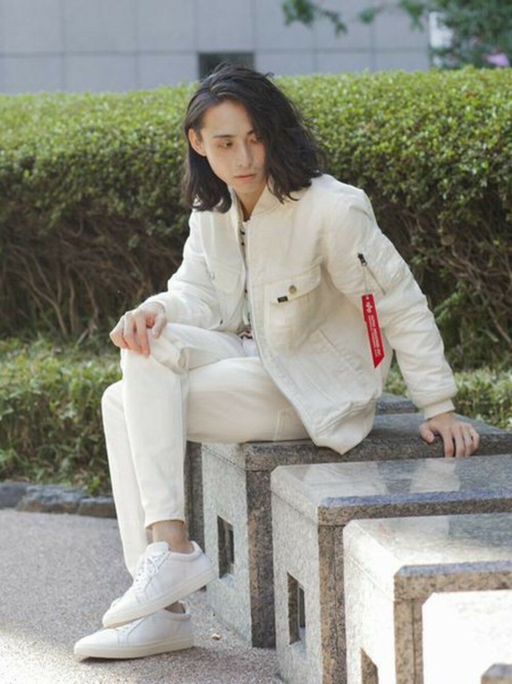 ホワイト系のミリタリージャケット、レッド系のTシャツ/カットソー、ホワイト系のスニーカーを着用したメンズの冬コーディネートの1枚目の写真
