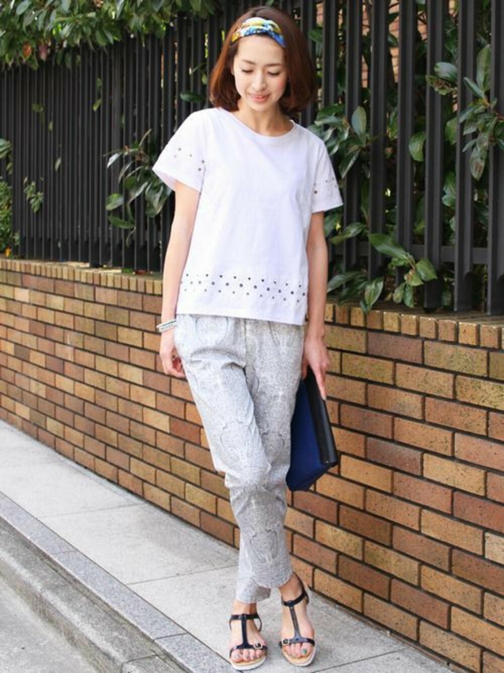 ホワイト系のTシャツ/カットソー、グレー系のその他パンツ、ブルー系のサンダルを着用したレディースの春コーディネートの1枚目の写真