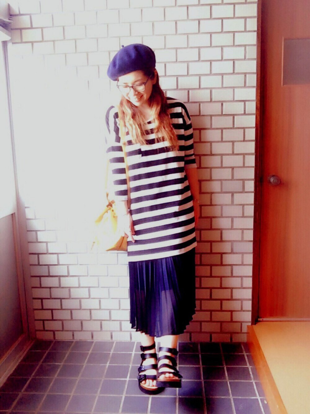 イエロー系のショルダーバッグ、ブラック系のサンダル、ブルー系のスカートを着用したレディースの春コーディネートの1枚目の写真