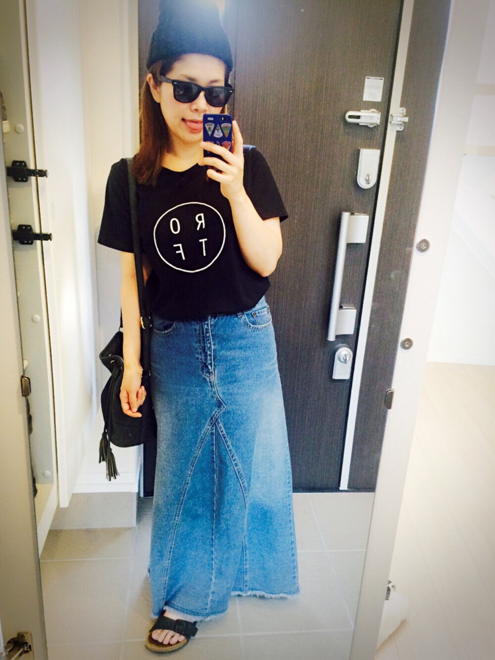 ブラック系のTシャツ/カットソー、グレー系のショルダーバッグ、ブルー系のデニムスカートを着用したレディースの春コーディネートの1枚目の写真