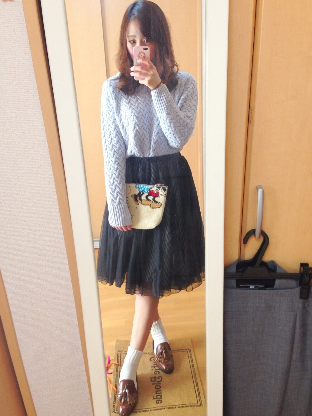 ブルー系のニット/セーター、ブラック系のスカート、ブラウン系のパンプスを着用したレディースの冬コーディネートの1枚目の写真