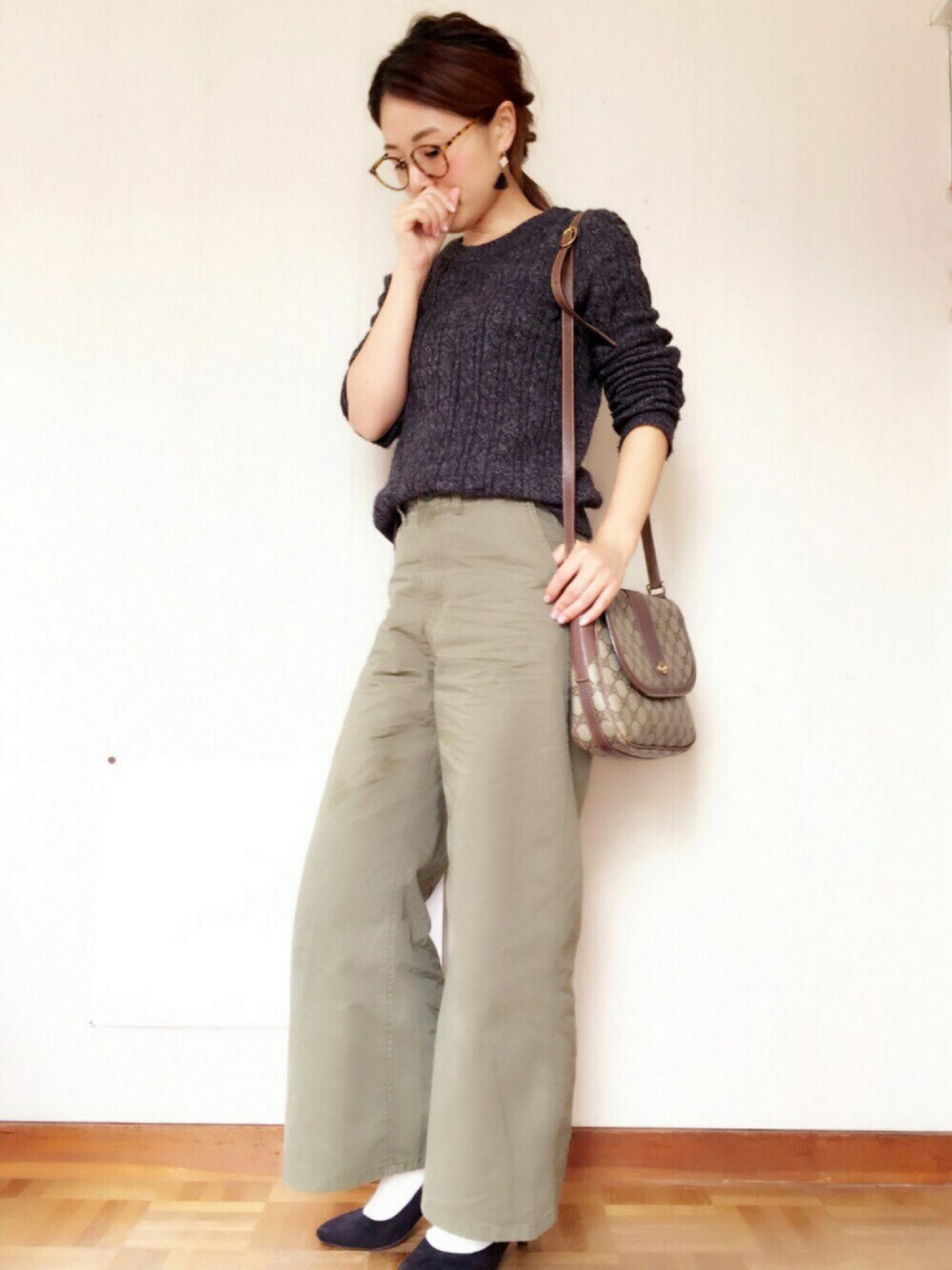 グレー系のニット/セーター、ブラウン系のショルダーバッグ、グリーン系のチノパンツを着用したレディースの秋コーディネートの1枚目の写真