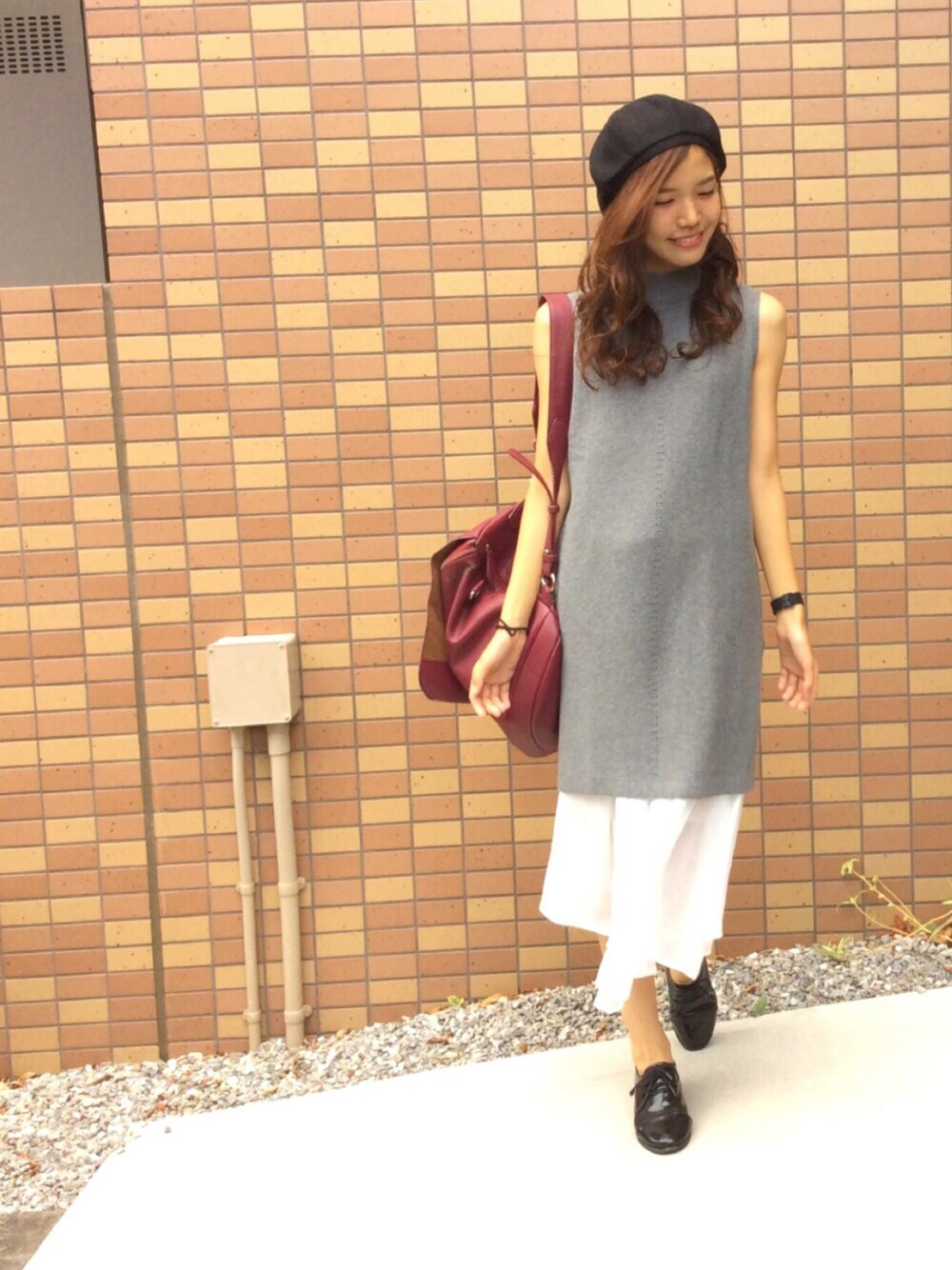 グレー系のニット/セーター、ホワイト系のスカート、レッド系のバックパック/リュックを着用したレディースの夏コーディネートの1枚目の写真