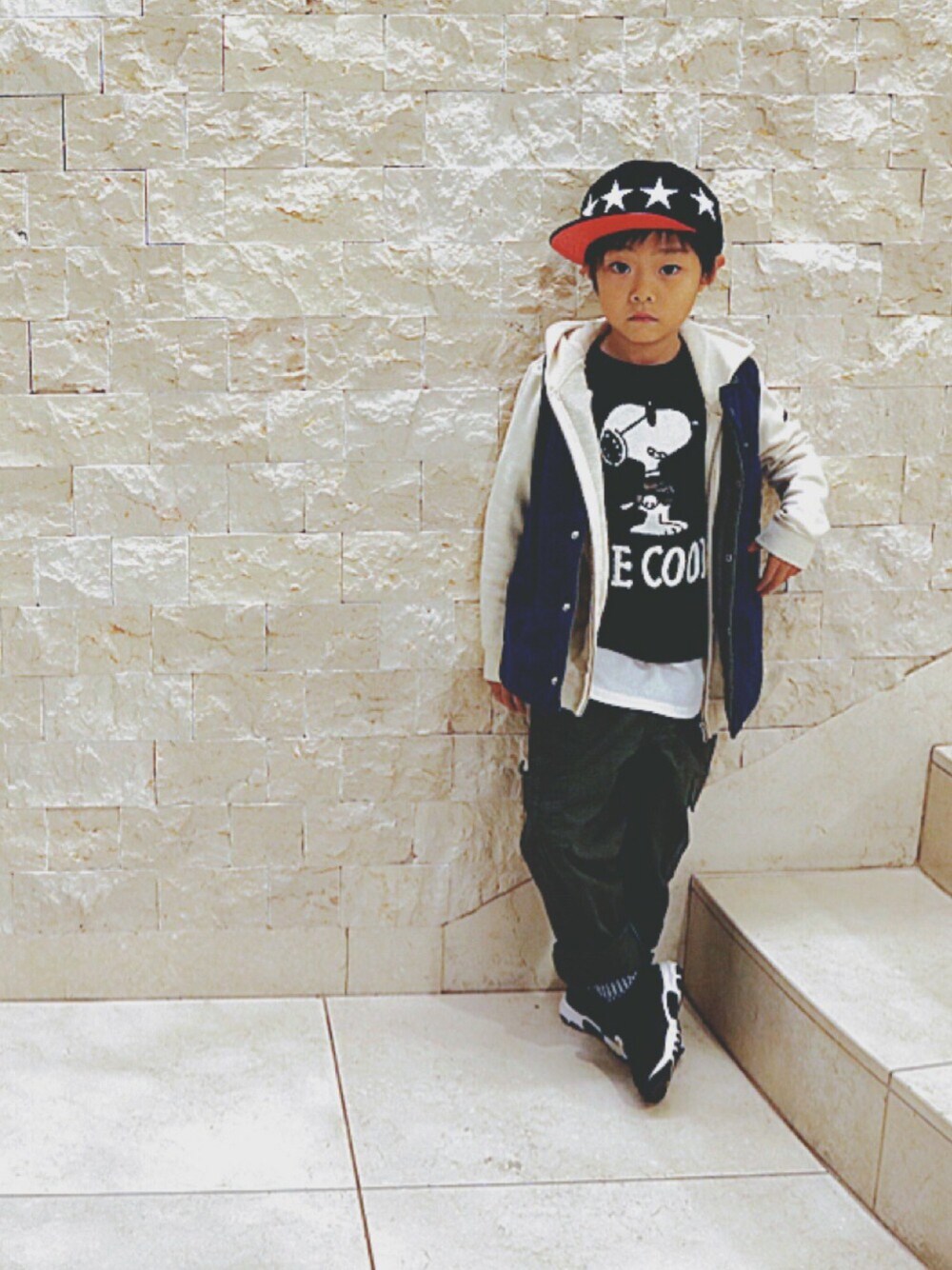 ホワイト系のパーカー、グリーン系のダウンベスト、ブラック系のTシャツ/カットソーを着用したキッズの冬コーディネートの1枚目の写真