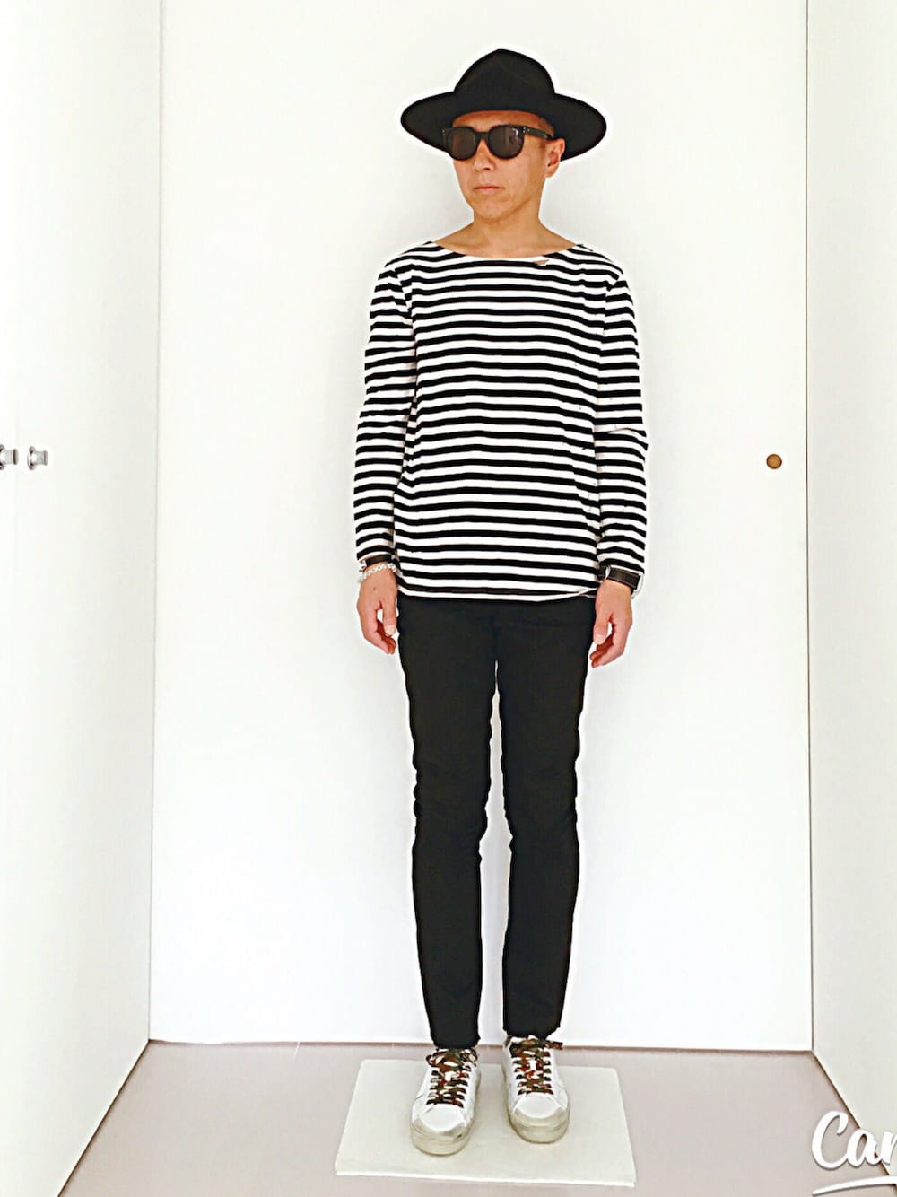ブラック系のTシャツ/カットソー、ブラック系のデニムパンツ、ホワイト系のスニーカーを着用したメンズの春コーディネートの1枚目の写真