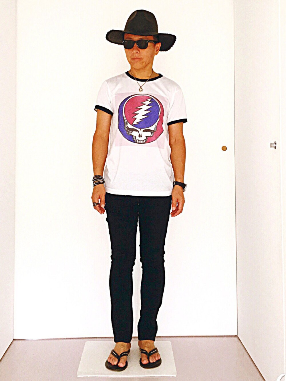 ホワイト系のTシャツ/カットソー、ブラック系のサンダル、ブラック系のデニムパンツを着用したメンズの夏コーディネートの1枚目の写真