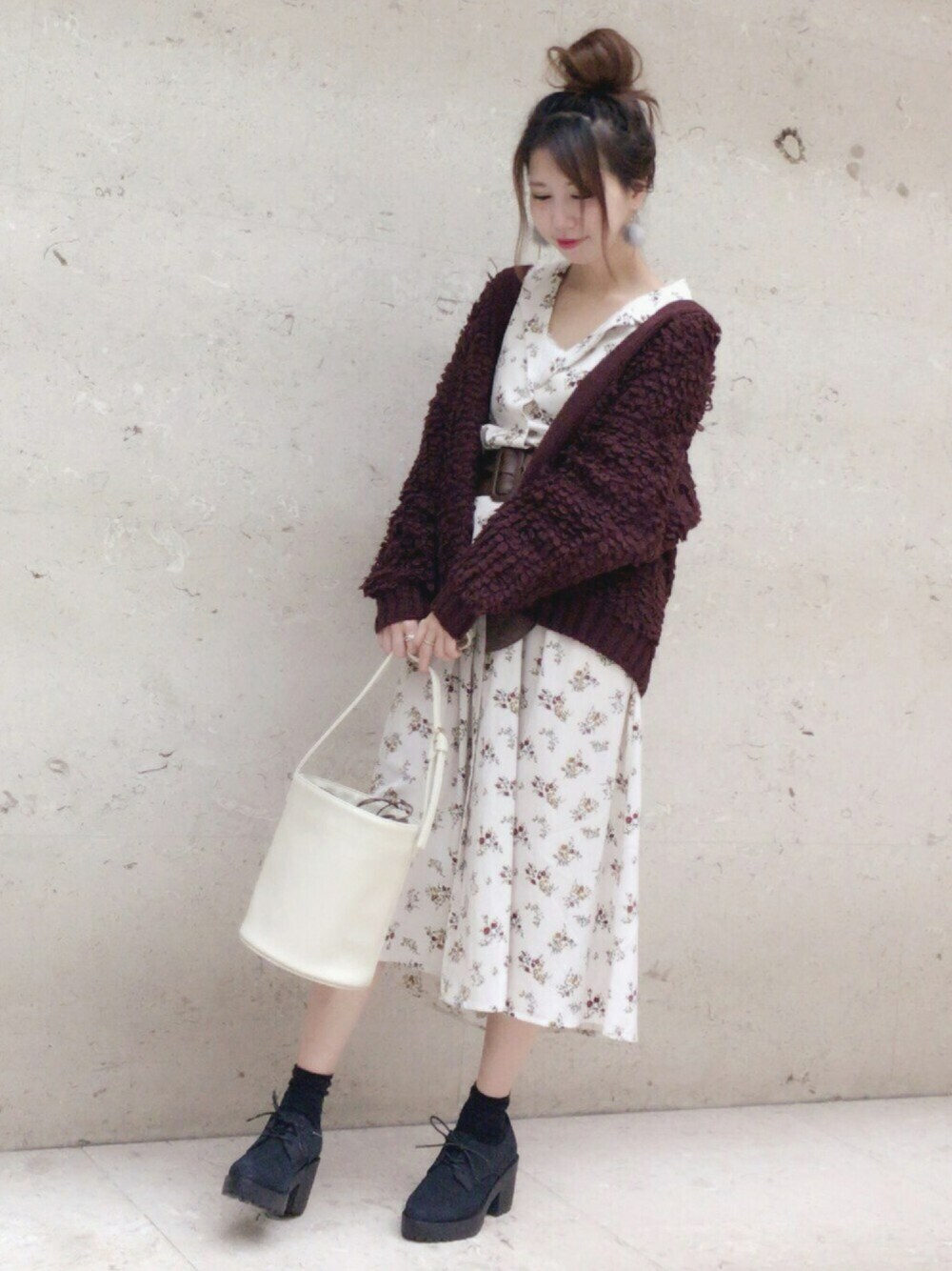 ブラック系のブーティ、ブラウン系のカーディガン/ボレロ、ホワイト系のショルダーバッグを着用したレディースの秋コーディネートの1枚目の写真