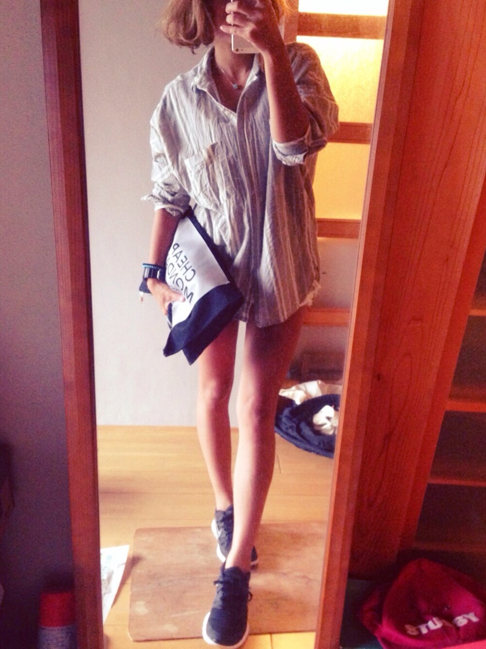 ブルー系のクラッチバッグ、ブルー系のネックレス、ブラック系のアナログ腕時計を着用したレディースの秋コーディネートの1枚目の写真