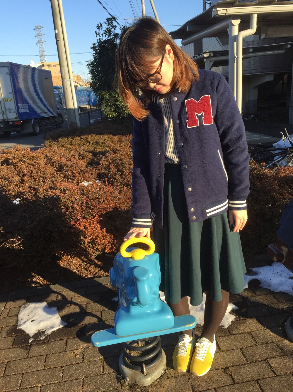 ホワイト系のTシャツ/カットソー、グリーン系のスカート、イエロー系のスニーカーを着用したレディースの冬コーディネートの1枚目の写真