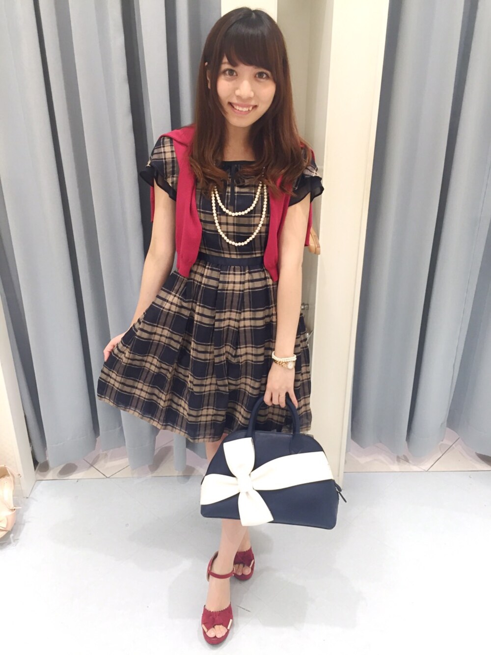 ブルー系のワンピース、ピンク系のカーディガン/ボレロ、ブルー系のハンドバッグを着用したレディースの夏コーディネートの1枚目の写真