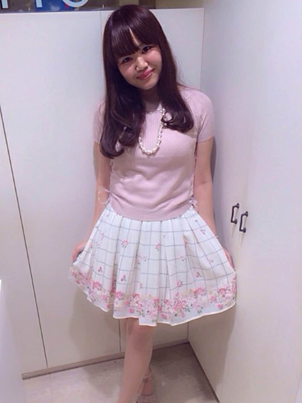 ピンク系のニット/セーター、ベージュ系のスカートを着用したレディースの夏コーディネートの1枚目の写真