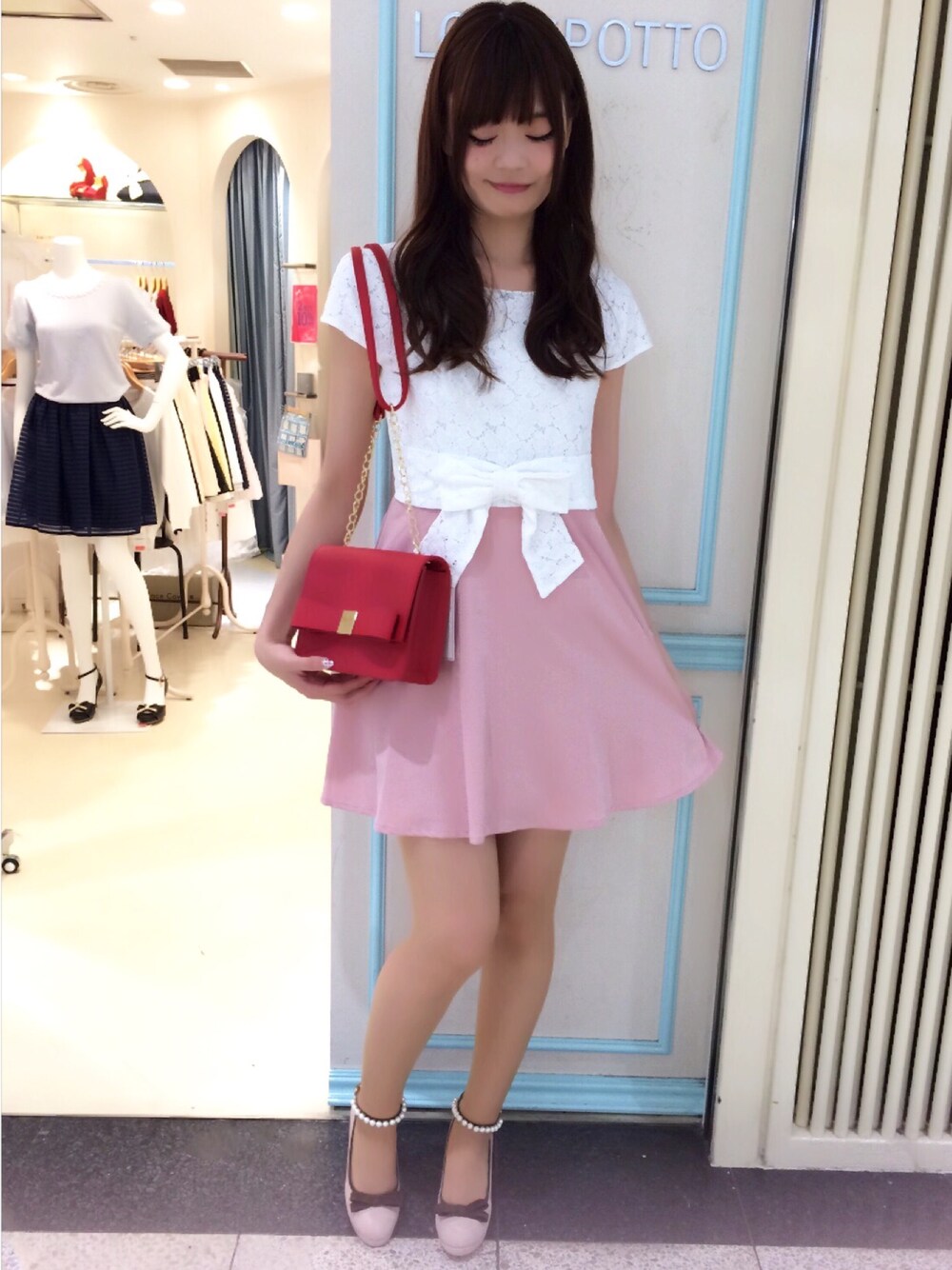 ピンク系のワンピース、レッド系のショルダーバッグ、ピンク系のパンプスを着用したレディースの夏コーディネートの1枚目の写真