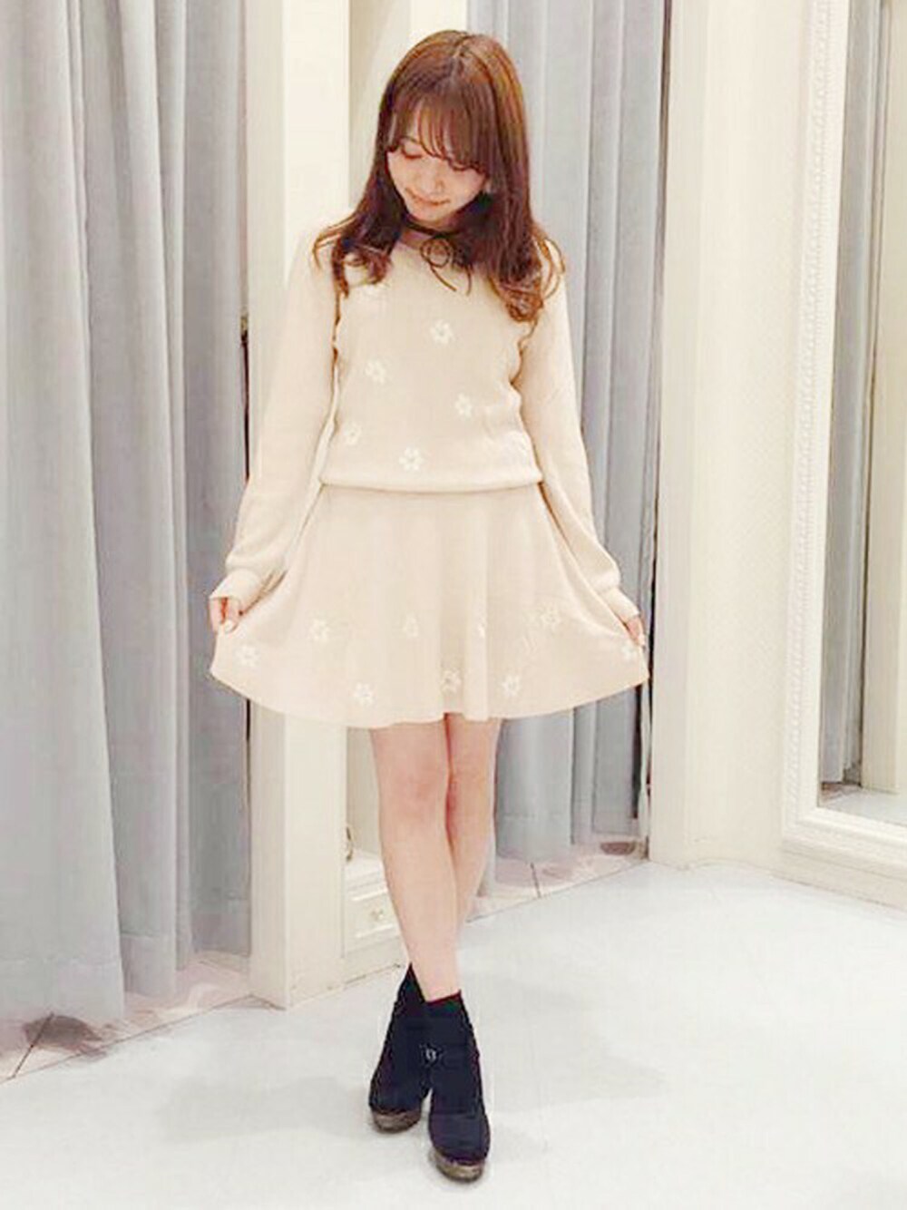 ピンク系のニット/セーター、ピンク系のスカートを着用したレディースの秋コーディネートの1枚目の写真