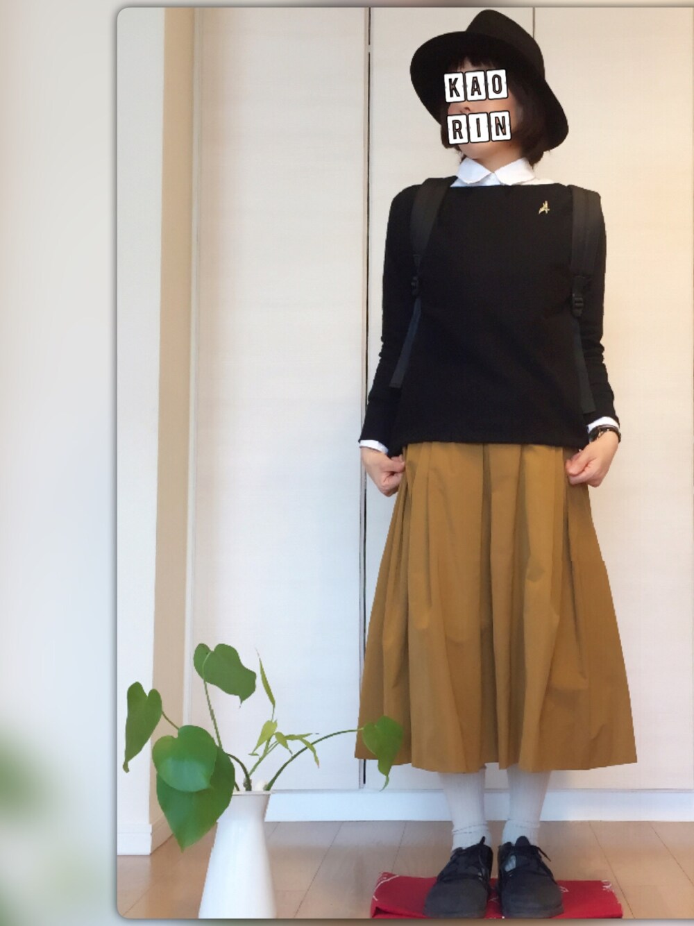 ブラック系のニット/セーター、ホワイト系のシャツ/ブラウス、ブラック系のバックパック/リュックを着用したレディースの秋コーディネートの1枚目の写真