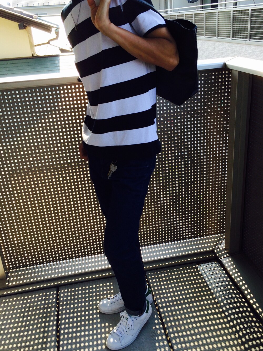 ブルー系のデニムパンツ、ブラック系のトートバッグ、ブラック系のTシャツ/カットソーを着用したメンズの夏コーディネートの1枚目の写真