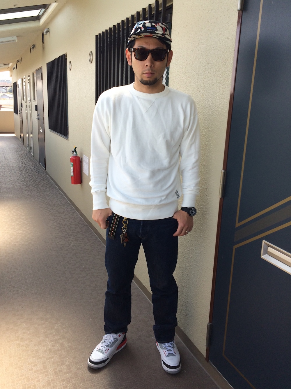 ホワイト系のスウェット、ブルー系のデニムパンツ、ホワイト系のスニーカーを着用したメンズの春コーディネートの1枚目の写真