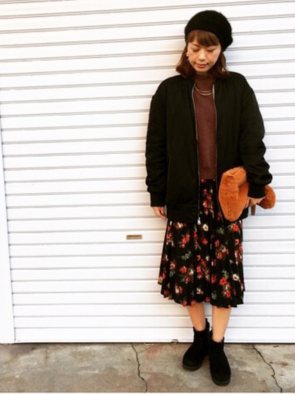 ブラック系のその他アウター、ブラック系のスカート、オレンジ系のクラッチバッグを着用したレディースの秋コーディネートの1枚目の写真