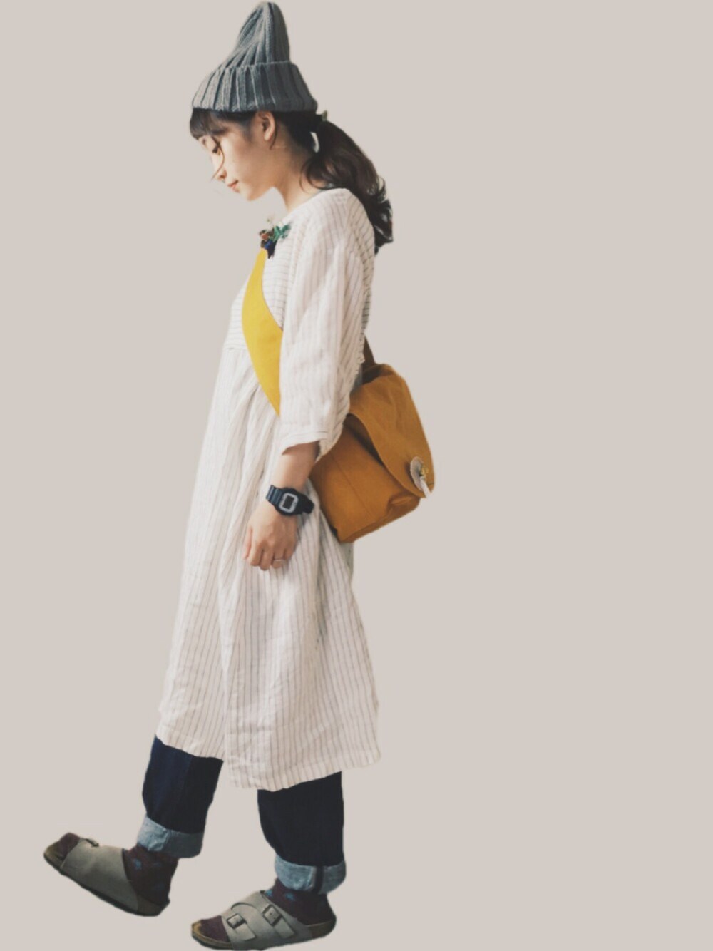 オレンジ系のショルダーバッグ、ホワイト系のワンピース、ブルー系のデニムパンツを着用したレディースの秋コーディネートの1枚目の写真