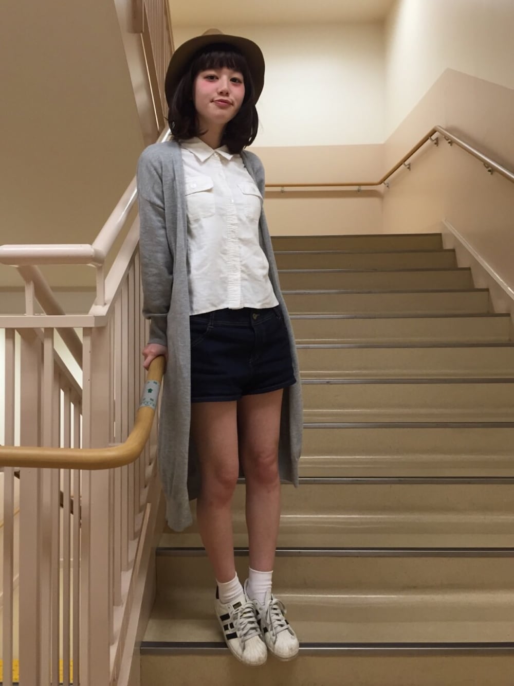ブルー系のデニムパンツ、ホワイト系のスニーカーを着用したレディースの春コーディネートの1枚目の写真